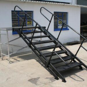 Aluminium hand railing with integrated stairs and safety handrails, designed for event access and crowd control, mounted on a concrete surface.