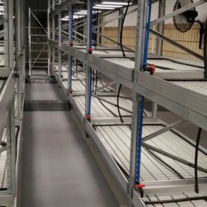 Aluminium trussing system with multi-tiered shelving in an industrial warehouse setting, designed for event staging and structural support.