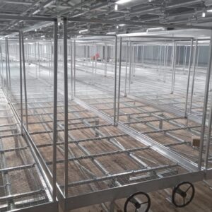 Aluminium trussing framework with adjustable wheels, used for modular stage or event structure support in an industrial setting.