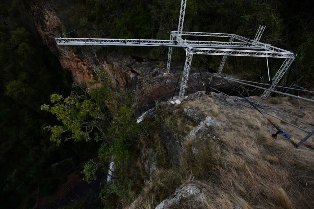 Aluminium trussing structure installed on a rocky hillside, supporting overhead cables and equipment for event or engineering applications.