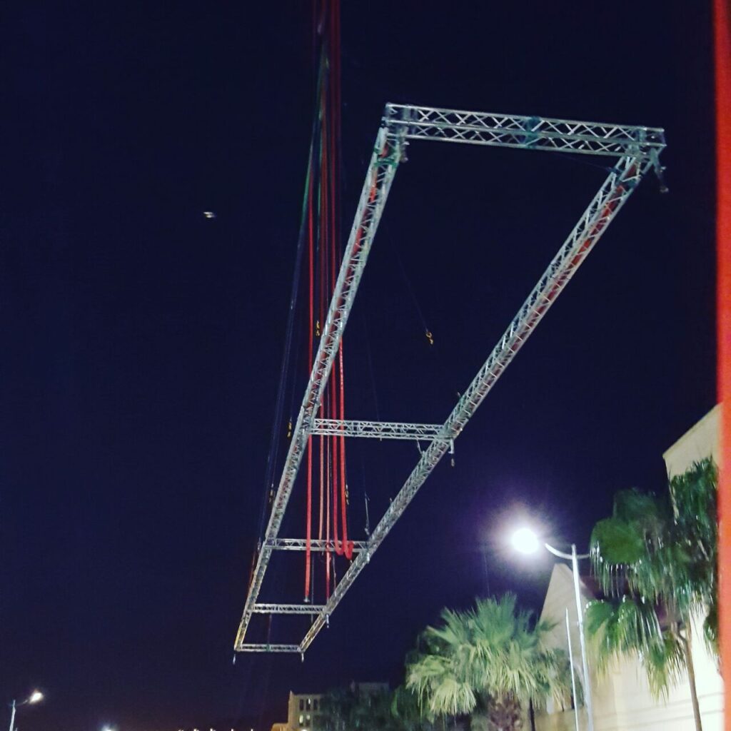 Aluminium trussing structure suspended in the air at night, used for event lighting and rigging support in professional production setups.