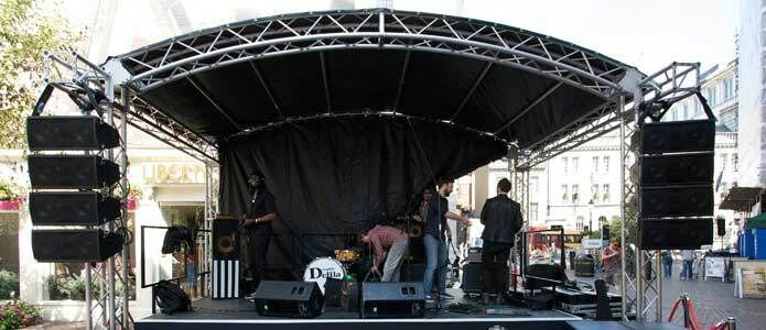 Aluminium trussing stage setup with black fabric backdrop, professional audio speakers, and lighting, designed for event production and engineering ap.
