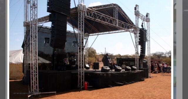 Aluminium trussing stage structure with integrated lighting and sound equipment for outdoor event production and engineering applications.