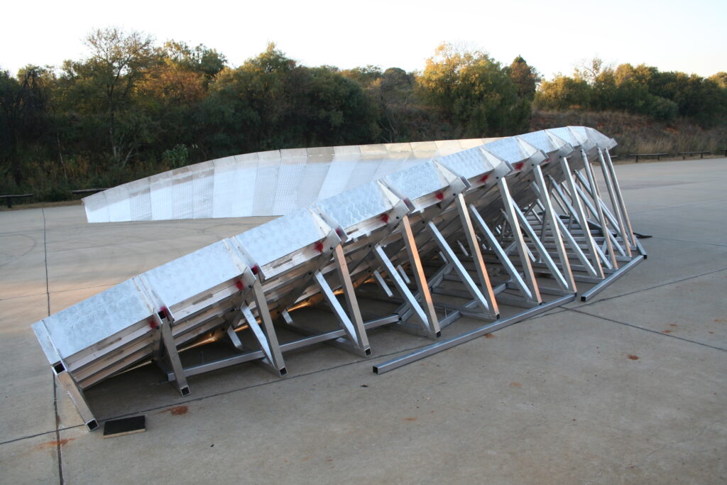 Aluminium trussing structure with multiple interconnected sections, designed for event rigging and support, set on a concrete surface outdoors.